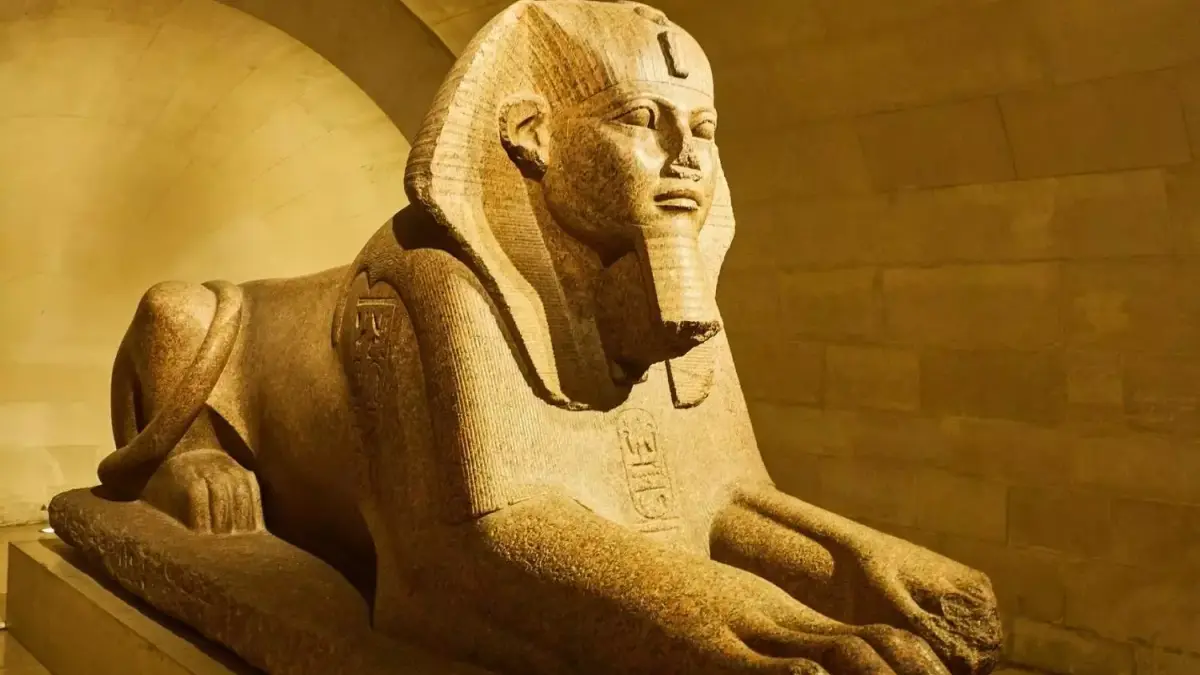 Le grand Sphinx de Tanis, au musée du Louvre, éclairé de côté sur un fond sombre