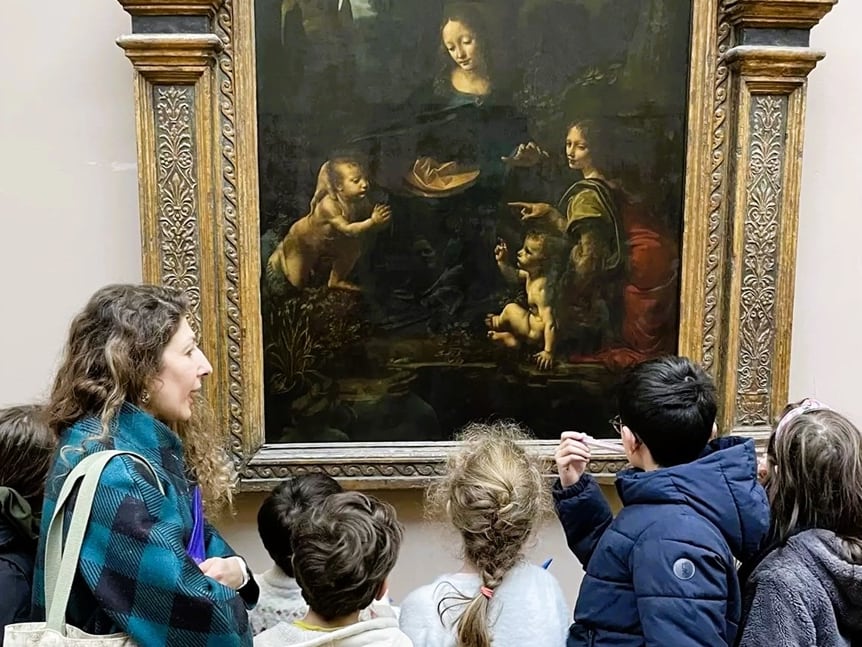 Des enfants et leur accompagnatrice observent un tableau de Léonard de Vinci