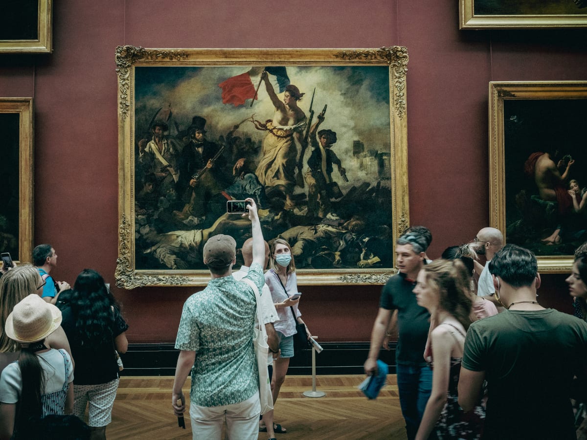 Des visiteurs devant La Liberté guidant le peuple de Delacroix, au Louvre